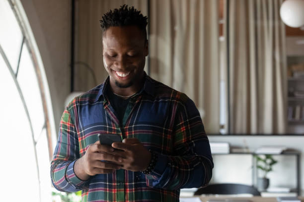 istock Smiling African American man use cellphone communicate online 1337424373