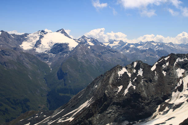 istock Snowcapped rocky summit at altitude in alps. 1337427157