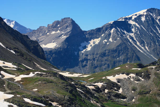 istock Snowcapped rocky summit at altitude in alps. 1337427879