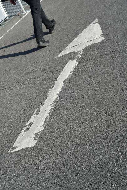 istock A large white arrow directional sign with a person walking alongside 1337428785