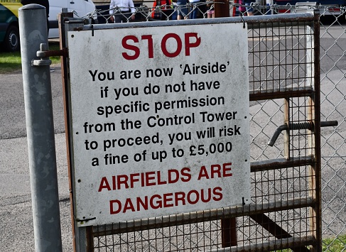A warning side stating Stop and airfields are dangerous
