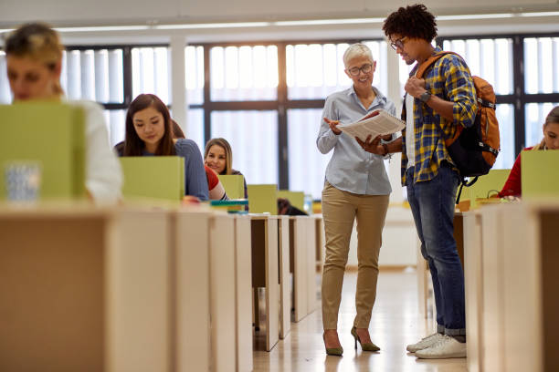 istock A female professor giving a help a student about new lesson. Smart young people study at the college. Education, college, university, learning and multiethnic people concept 1337429605