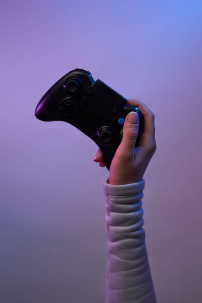 istock Hand with a game joystick on violet background. 1337429739