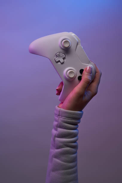 istock Hand with white game joystick on violet background. 1337429825