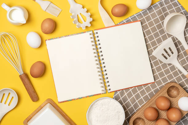 istock Baking ingredients, cooking utensil and open notebook on yellow background. Template for cooking recipes or your design. Top view Flat lay Mockup 1337429919