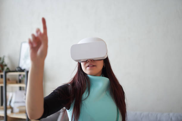 istock Woman is using virtual reality headset. Concept of virtual reality, gaming and future technology. 1337430526