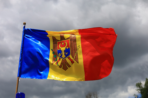The official flag of the state of the Republic of Moldova against the sky.