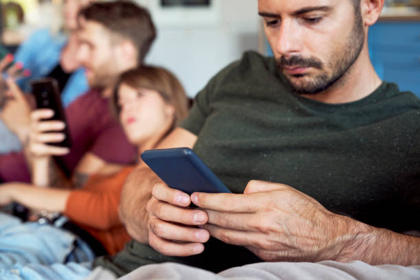 istock Man focused on smart phone at party 1337432247