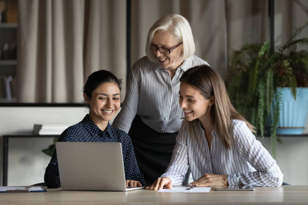 istock Smiling diverse colleagues with mature leader working on online project 1337433786