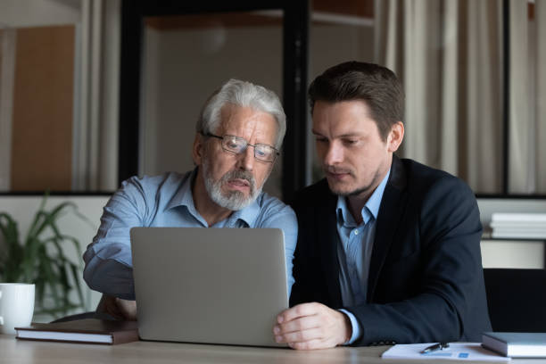 istock Confident mature businessman mentor training new employee, using laptop 1337433852