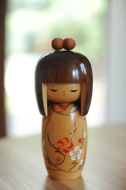 Photo of Japanese wooden kokeshi doll in kimono with brown hair