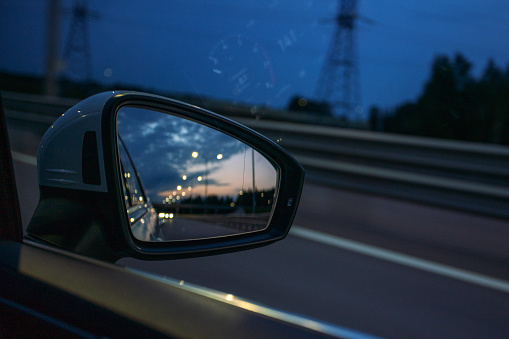 Rear view mirror of a car in the night trip