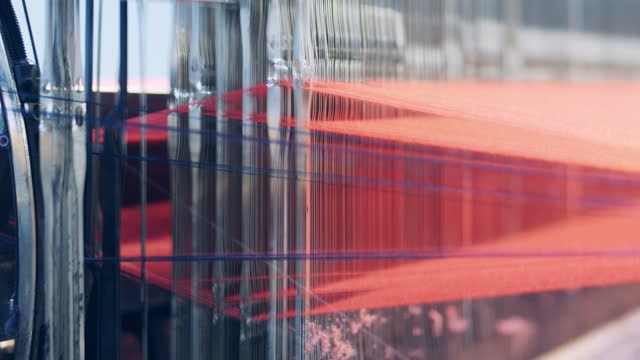 Close up of a weaving mechanism processing threads