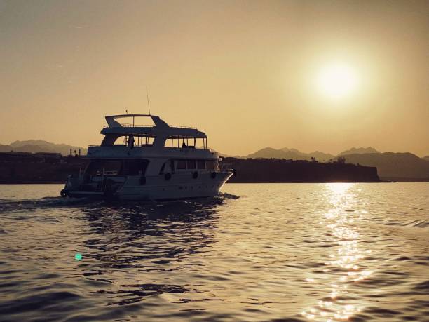 yacht in the sea at sunset - moody sky water sport passenger craft scenics imagens e fotografias de stock