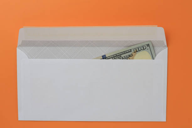 istock Classic white new mail envelope with dollars inside on an orange background. Copy space for text 1337442821