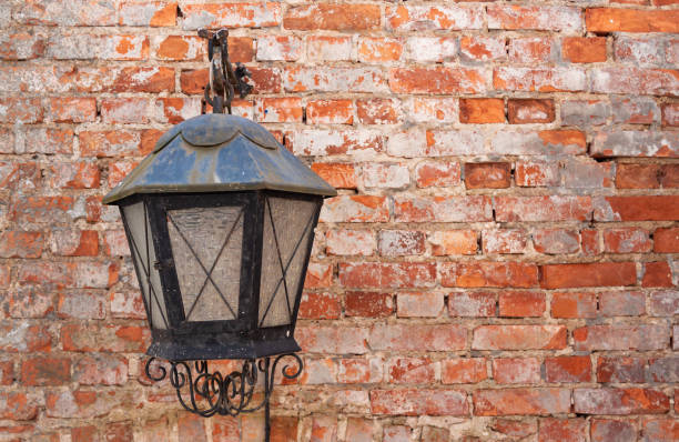 istock Old metal, black coloured lamp hanging at the red, old brickwall 1337443564