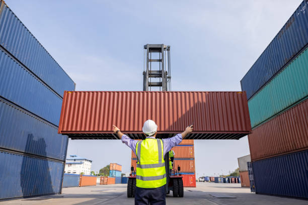 istock American man Foreman control loading containers box to truck for logistics export of International global shipping. Thailand 1337444467