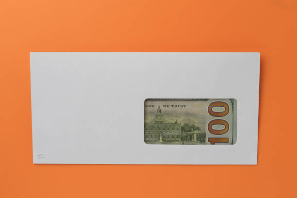 istock Classic white new mail envelope with dollars inside on an orange background. Copy space for text 1337444564