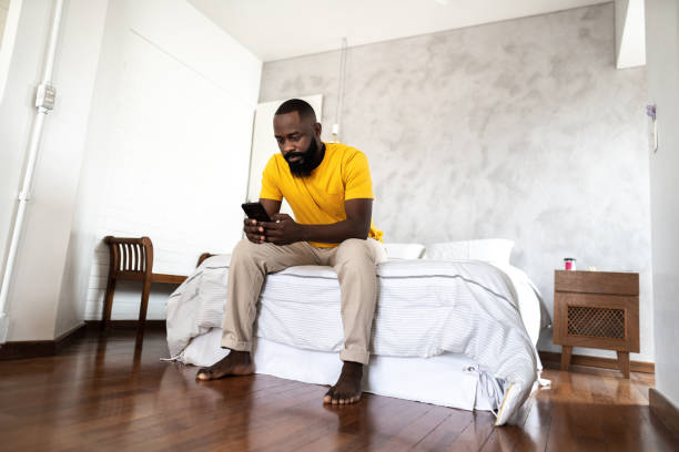 istock Mid adult man using smartphone at home 1337446113