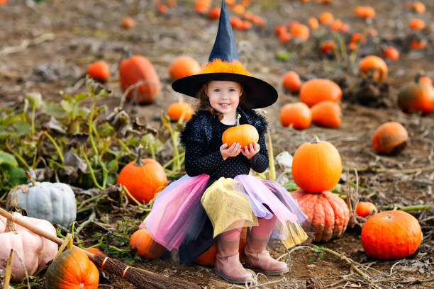 mała dziewczynka w halloweenowy kostium czarownicy na naszywce dyni - pumpkin child little girls pumpkin patch zdjęcia i obrazy z banku zdjęć