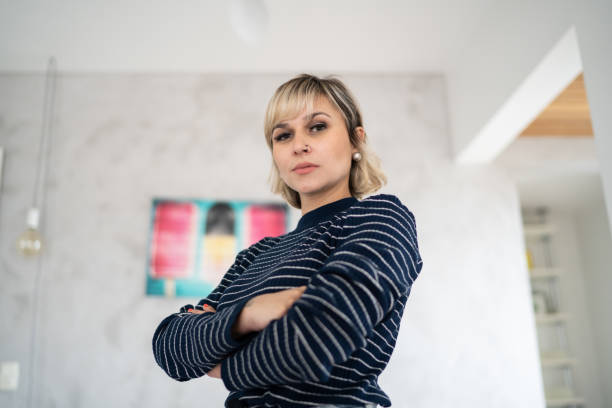 retrato de una mujer mediana adulta seria en casa - vista de ángulo bajo fotografías e imágenes de stock