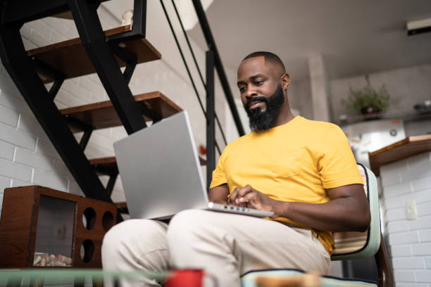istock Mid adult man using laptop at home 1337447725