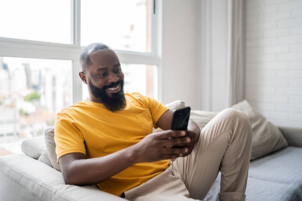 istock Happy mid adult man using smartphone at home 1337447752