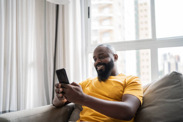 istock Happy mid adult man using smartphone at home 1337447909