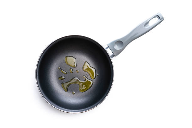 Overhead view of a new skillet with cooking oil spills isolated on white background.