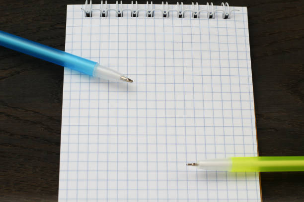 istock Open blank notebook and two pens. Mockup with copy space. Wood background. Selective focus 1337449253