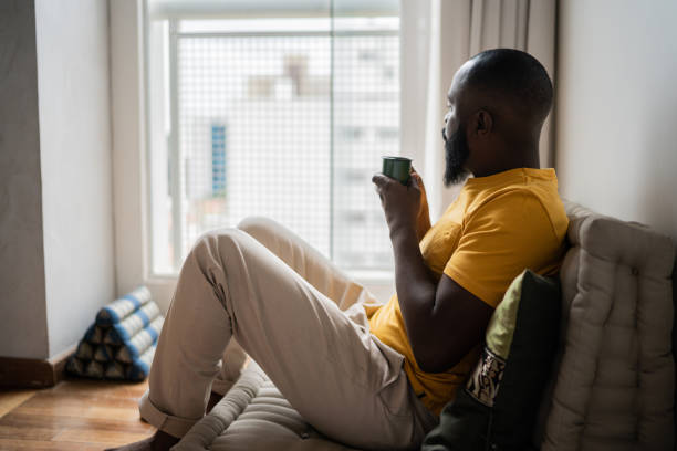 istock Man contemplating and holding mug at home 1337449788