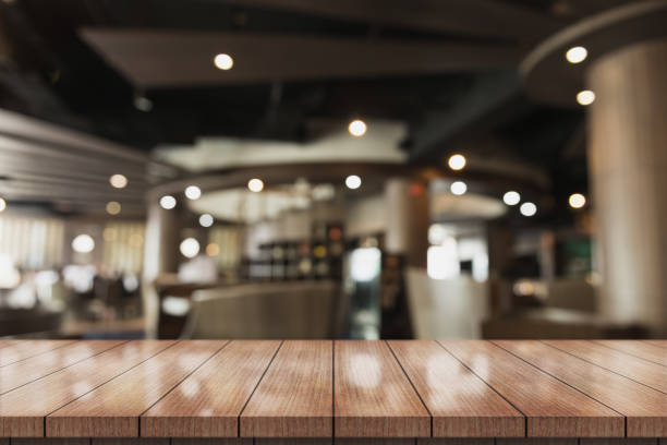 istock Empty wooden table top with lights bokeh on blur restaurant background. 1337452269