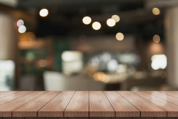 istock Empty wooden table top with lights bokeh on blur restaurant background. 1337452291