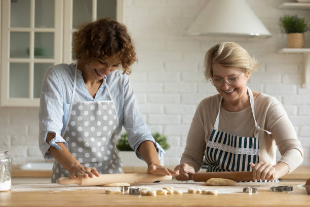 szczęśliwa kobieta z dojrzałą matką gotującą, zwijającą ciasto razem - grandmother pie cooking baking zdjęcia i obrazy z banku zdjęć