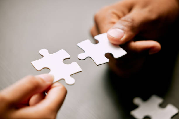 Closeup shot of two unrecognizable businesspeople holding puzzle pieces together This looks like a perfect match co ordination stock pictures, royalty-free photos & images