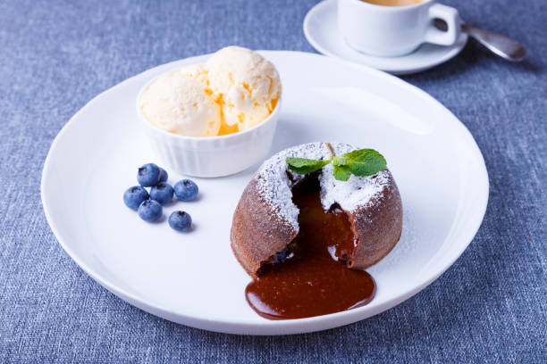 pastel de lava con llenado líquido fluido. fondant de pastel de chocolate con helado de vainilla, arándanos, menta y café. francés tradicional - coffee muffin pastry blueberry muffin fotografías e imágenes de stock