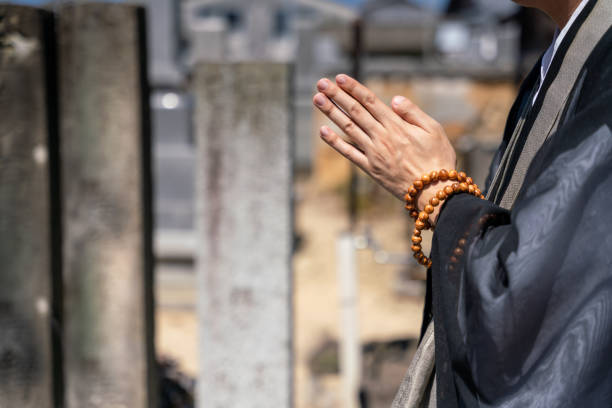 A monk praying in front of the tomb