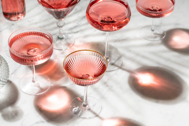 pink rose cocktail or mocktail with sunny summer light on white marble - martini glass imagens e fotografias de stock