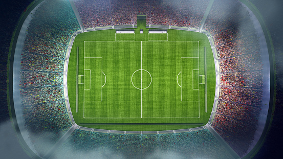 Professional soccer stadium with tribunes, illumination, green grass and cloudy blue sky