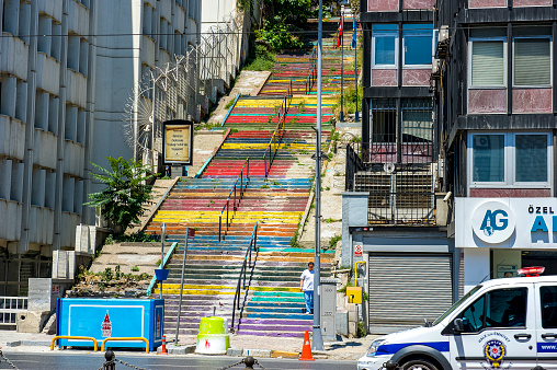 A series of colorful stairs flow down from a hilly section of Istanbul, Turkey down to the main promenade along the harbor area.