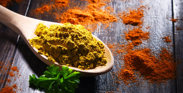 istock Wooden spoon with curry powder on kitchen table 1337464954