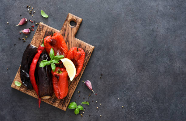 istock Baked vegetables: eggplant and peppers on a wooden board on a black background. 1337465401
