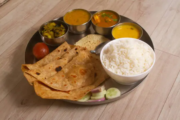 Indian Fasting cuisine Upwas items Thali complere meal for vrat ekadashi.Upawas thali meal with Rajgira puri, paratha,shakarkand halwa,alu sabji,amaranth sheera pakoda, sabudana ata dhokla, chips