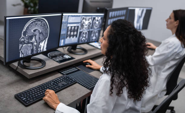 врачи, работающие с компьютером и анализируя медицинские сканирования - brain mri scanner mri scan medical scan стоковые фото и изображения