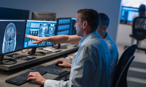 コンピュータを扱い、医療スキャンを分析する医師 - radiologist ストックフォトと画像