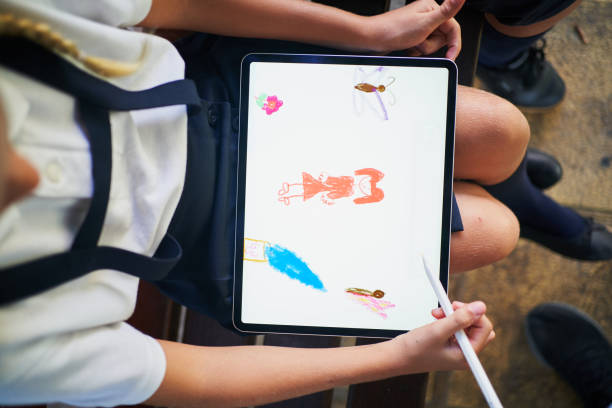 top view of spanish school girl drawing on a tablet in park - school bench above bildbanksfoton och bilder