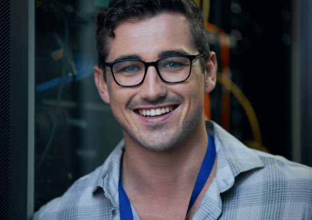 istock Cropped portrait of a handsome young male programmer working in a server room 1337471395
