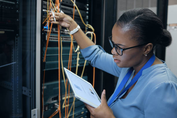 istock Cropped shot of an attractive female programmer working on a tablet in a server room 1337471407