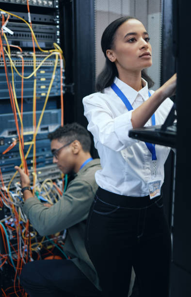 istock Cropped shot of two young computer programmers working together in a server room 1337471422