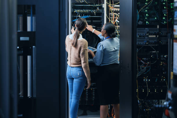 istock Rearview shot of two unrecognizable female programmers working together in a server room 1337471423